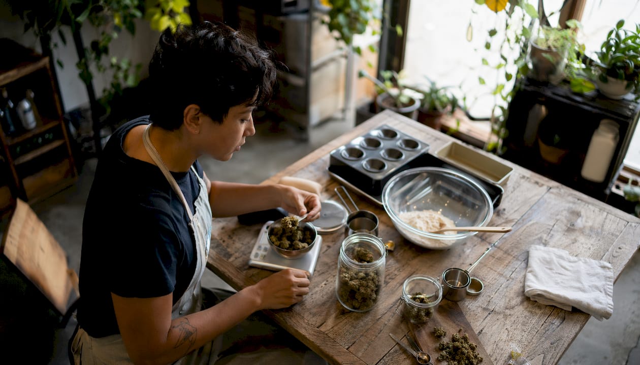 Person preparing cannabis for homemade edibles in kitchen